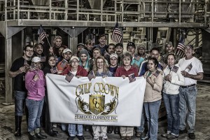 A photograph of the team at Gulf Crown Seafood holding up a banner with their company's logo.