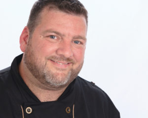 A headshot photograph of Chef Eric Lackey.