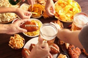A group of people eating game day snacks.