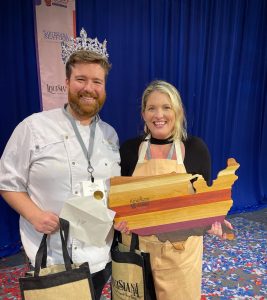 Chef Austin Sumrall takes a photo with his wife upon winning the 2021 Great American Seafood Cook-Off.