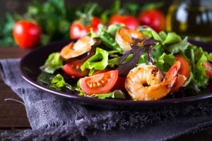A plate of shrimp salad with tomatoes.