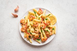 A plate of butternut squash pasta with shrimp.