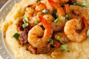 A close-up photograph of a plate of shrimp and grits.