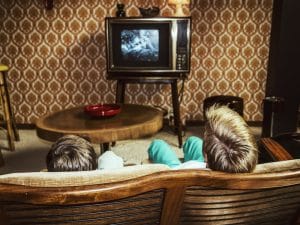 Two boys watching an old television.